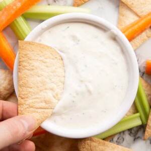 overhead shot of dunking tortilla chip into dip