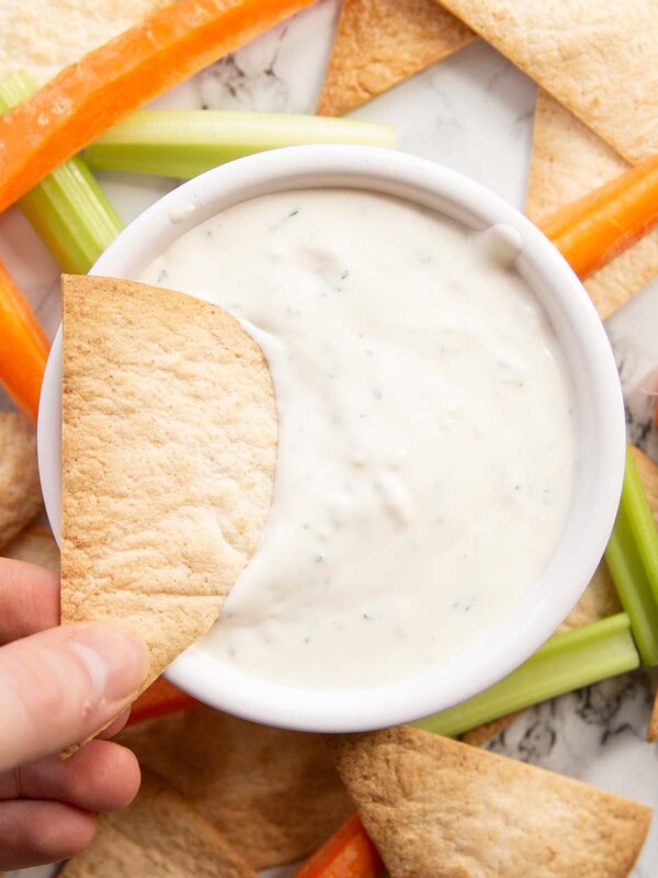 overhead shot of dunking tortilla chip into dip