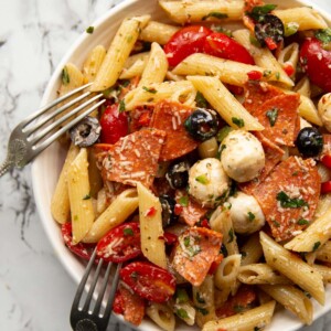 overhead shot of pasta in white bowl with two forks resting