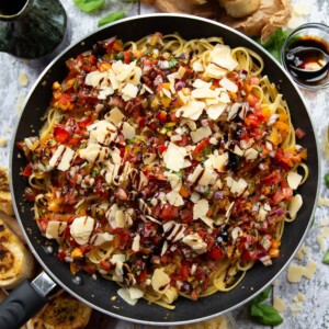 overhead shot of pasta in skillet surround by garnish