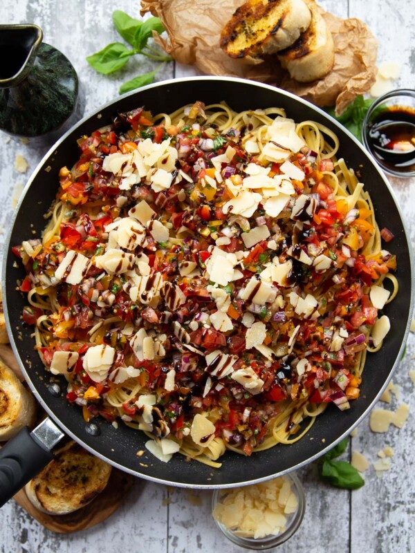 overhead shot of pasta in skillet surround by garnish