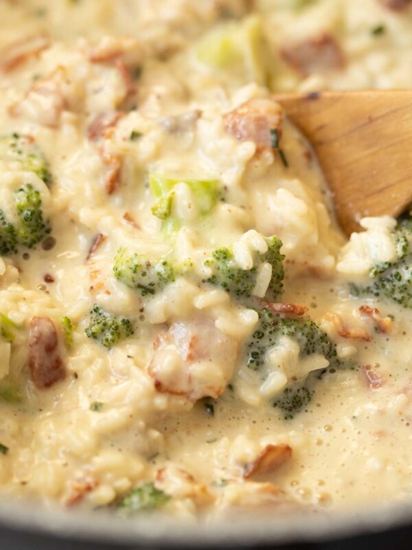 wooden spoon diving into rice in casserole dish