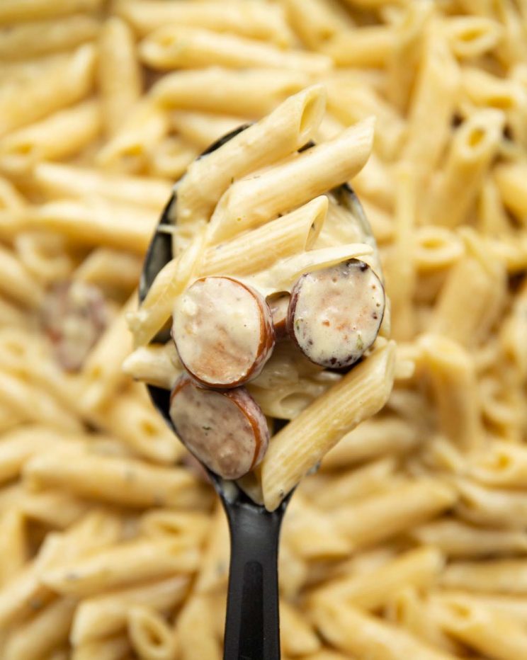 overhead shot of pasta on serving spoon with skillet of pasta blurred behind