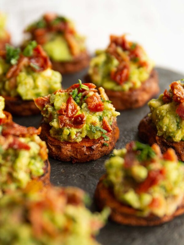 sweet potato bites on slate, focused on one in the middle garnished with coriander