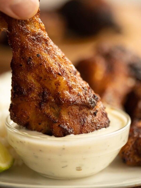 drumstick being dunked into small glass pot of ranch