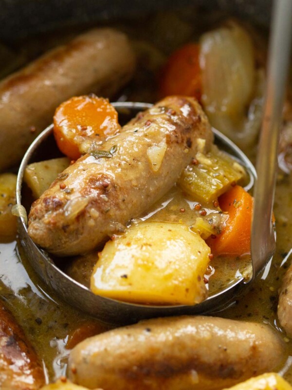 silver ladle in casserole scooping out sausage