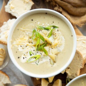 overhead shot of soup surround by buttered bread on chopping board