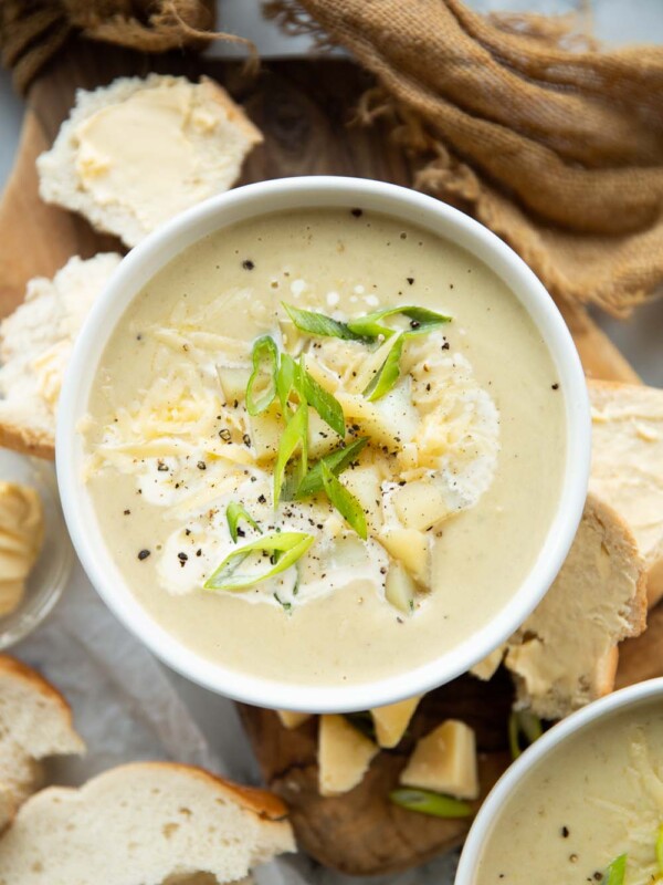 overhead shot of soup surround by buttered bread on chopping board