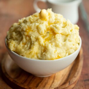 mashed potatoes served in small white bowl with jug blurred in background