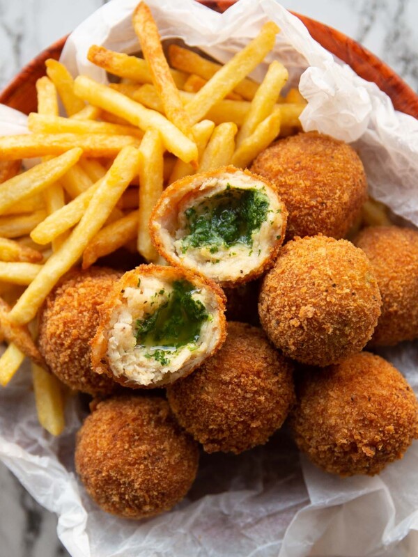 overhead shot of kievs and french fries in small bowl with a kiev split in half on top