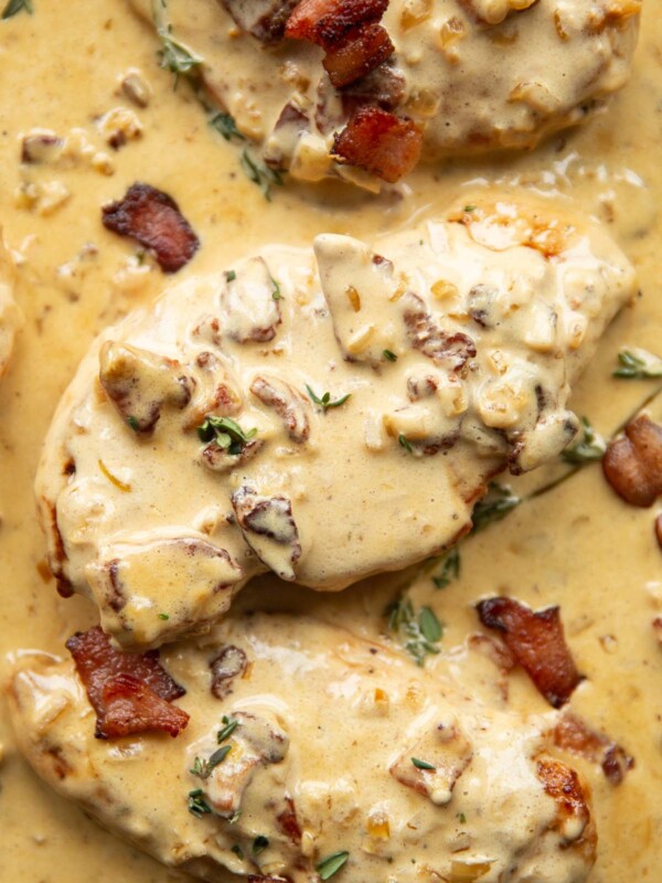 overhead shot of chicken breasts in creamy bacon sauce in skillet