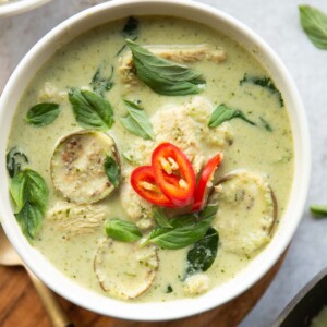 overhead shot of green curry in a small white bowl