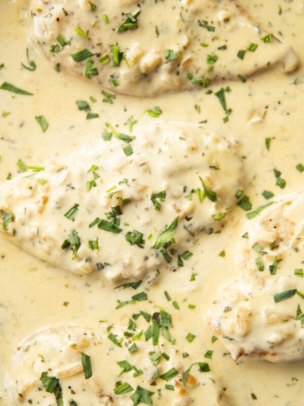 overhead shot of chicken in skillet garnished with tarragon