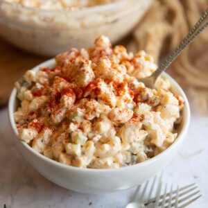 pasta salad served in a small white bowl with silver fork digging in