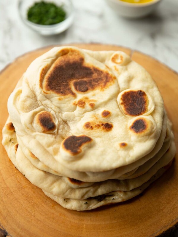 5 flatbreads stacked on each other on wooden board