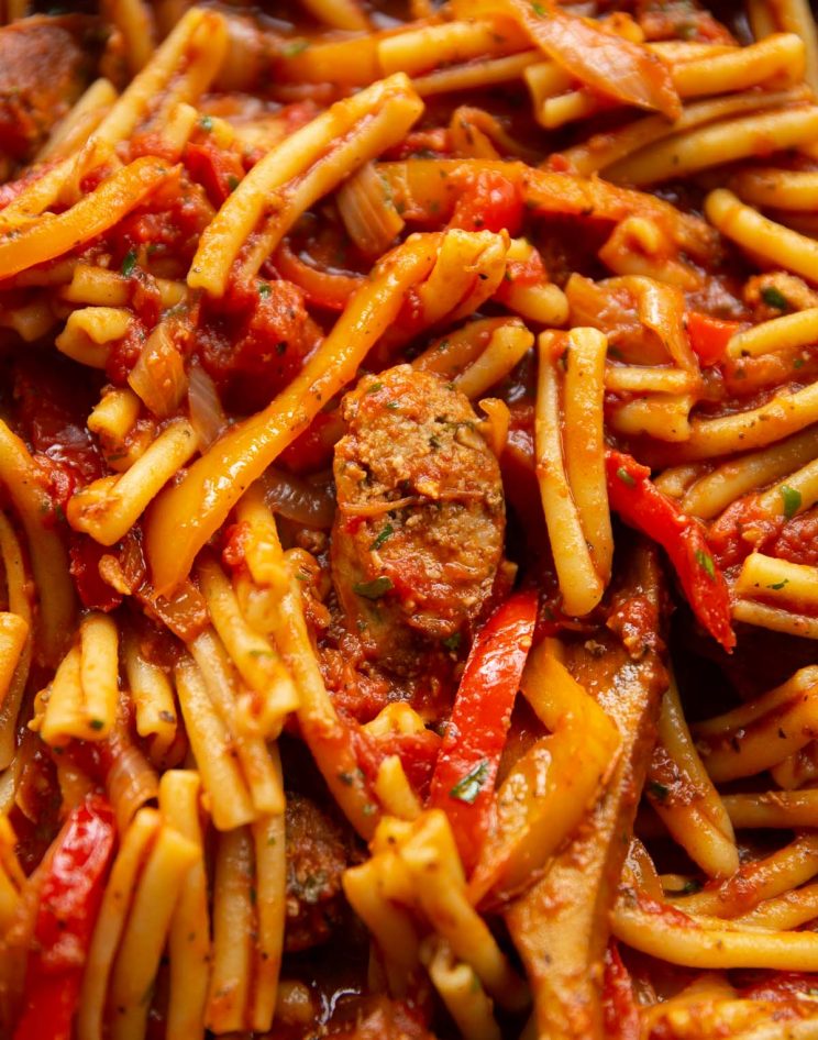 close up overhead shot of pasta in skillet with wooden spoon digging in