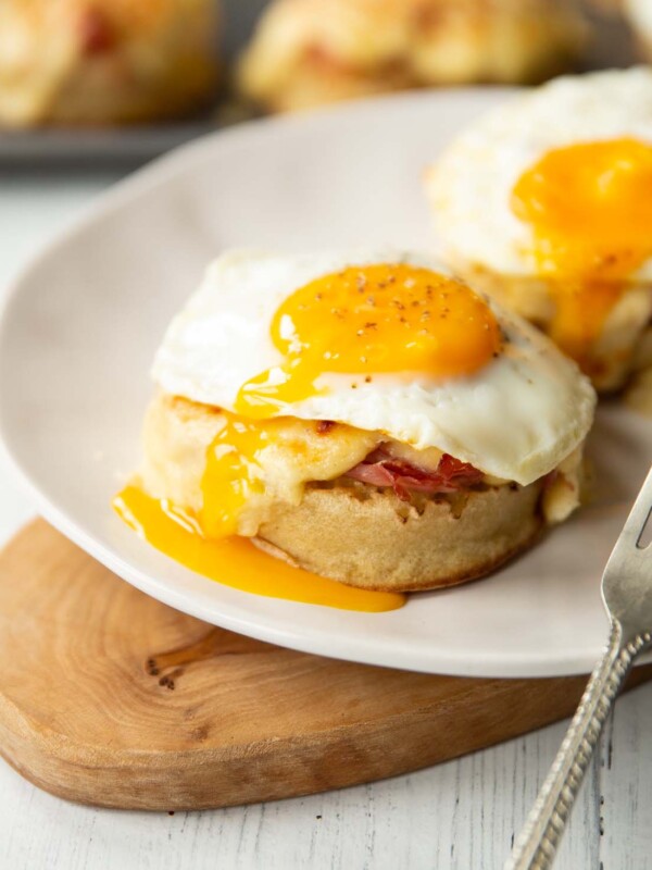 two madame crumpets on white plate on small wooden board with silver fork