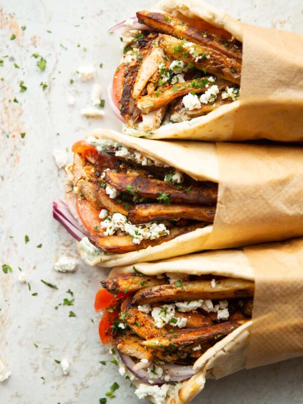 overhead shot of 3 chicken gyros wrapped in brown parchment paper