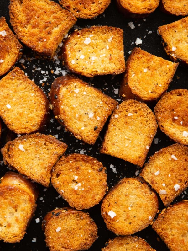 close up overhead shot of bagel chips fresh out the oven on black tray