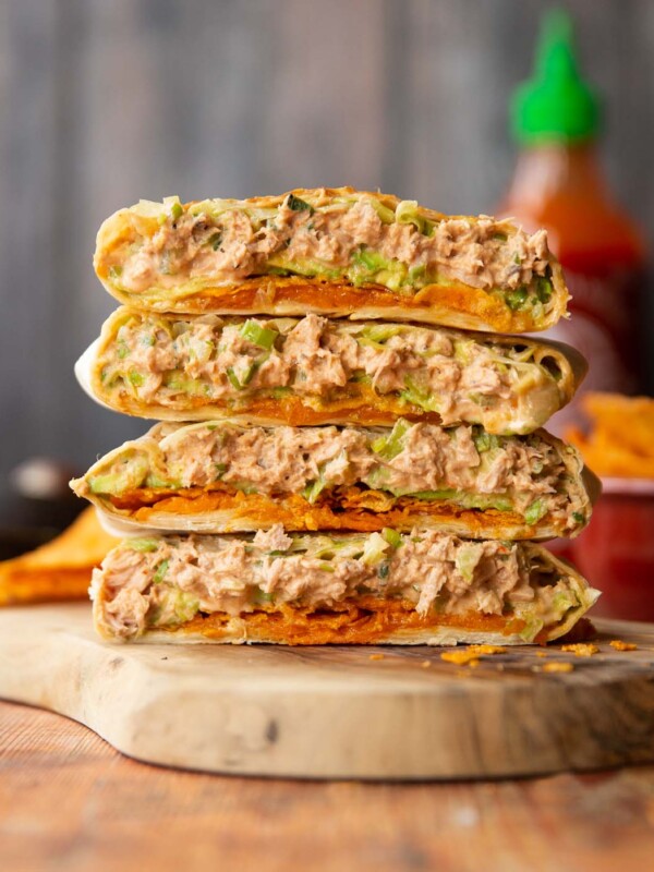 4 crunchwrap halves stacked on each other on wooden board showing filling