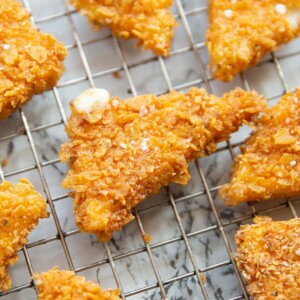 close up shot of Dorito crusted cheese triangles on wire rack garnished with sea salt