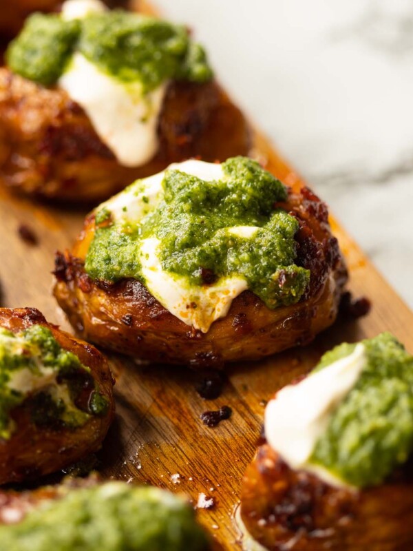 close up shot of pesto nduja potato on wooden chopping board