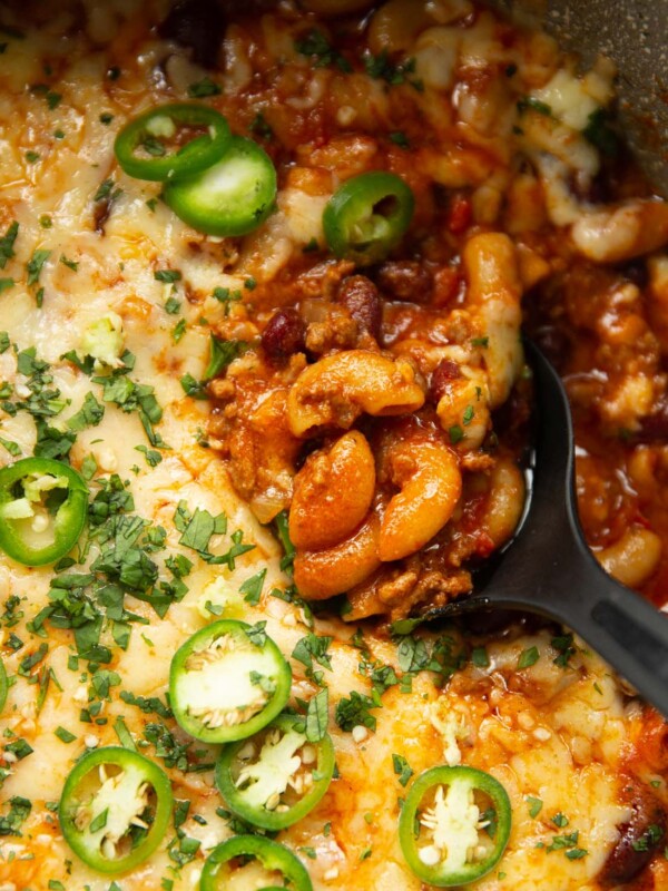 overhead close up shot of black serving spoon digging into pot of chili mac