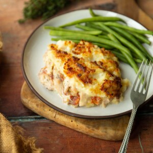 chicken and bacon pie on small white plate served with green beans