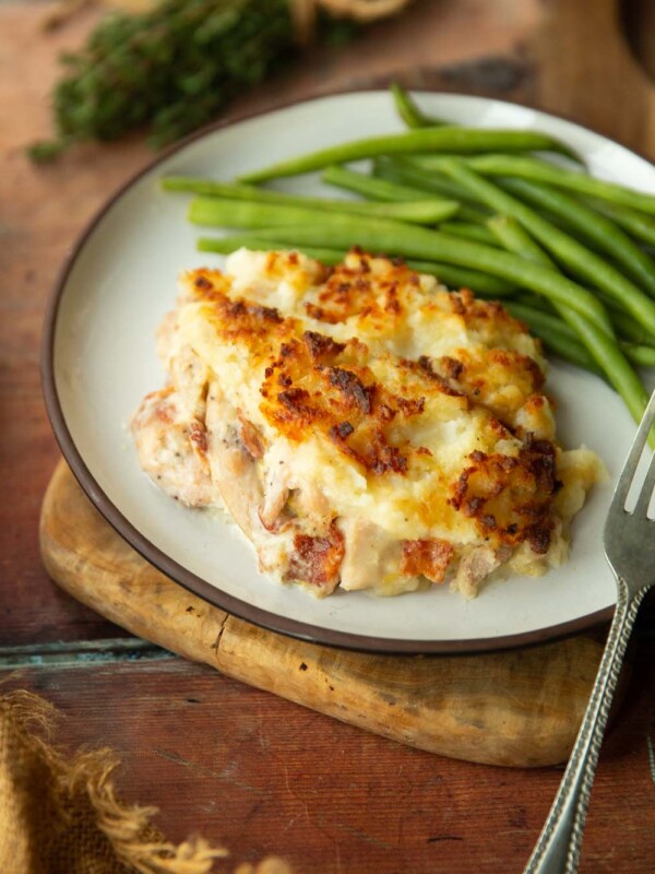 chicken and bacon pie on small white plate served with green beans