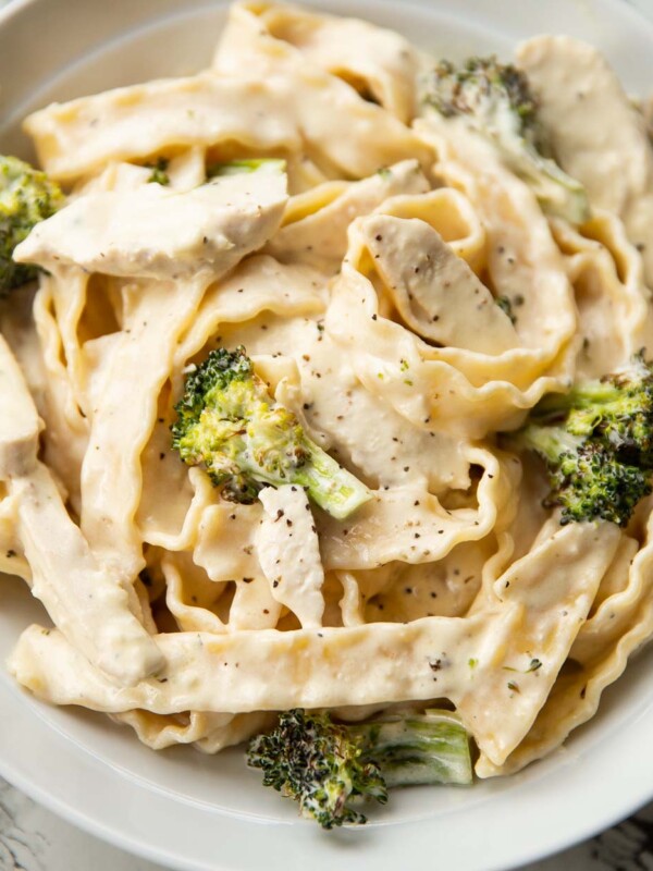 close up shot of pasta with chicken and broccoli in large white dish