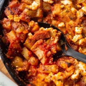 close up shot of black serving spoon digging in to chicken chorizo bake