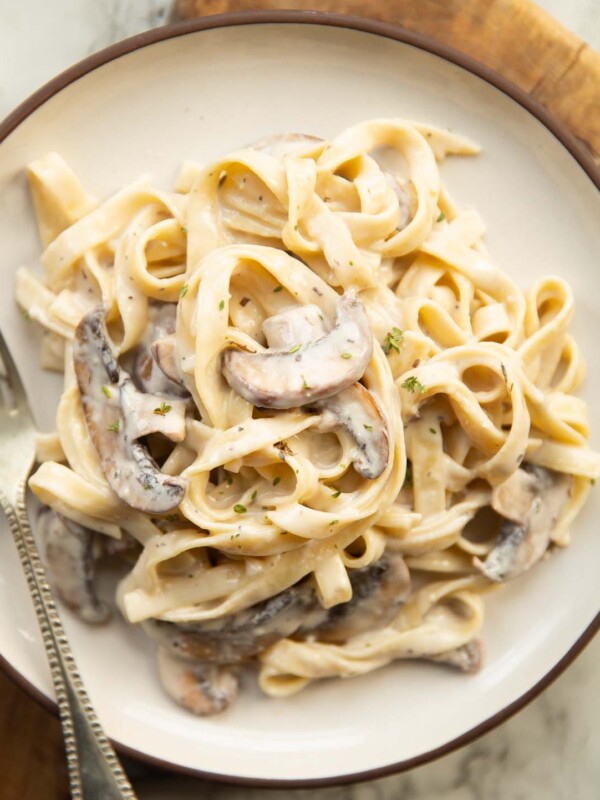 overhead shot of mushroom tagliatelle on small white plate with silver fork