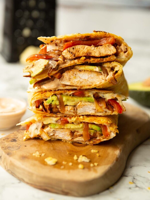 4 chipotle chicken quesadillas quarters stacked on each other on wooden board