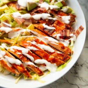 close up shot of buffalo chicken salad in large white dish on marble background