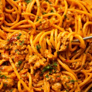 close up shot of fork twirling into pan of sausage harissa pasta