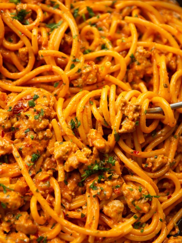 close up shot of fork twirling into pan of sausage harissa pasta