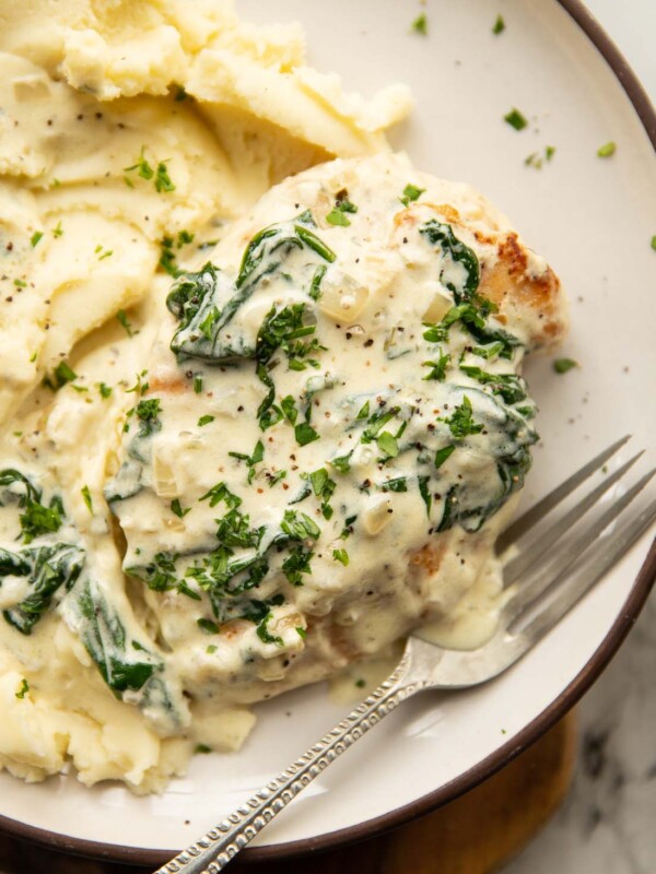 close up shot of Boursin chicken on small white plate with mashed potato