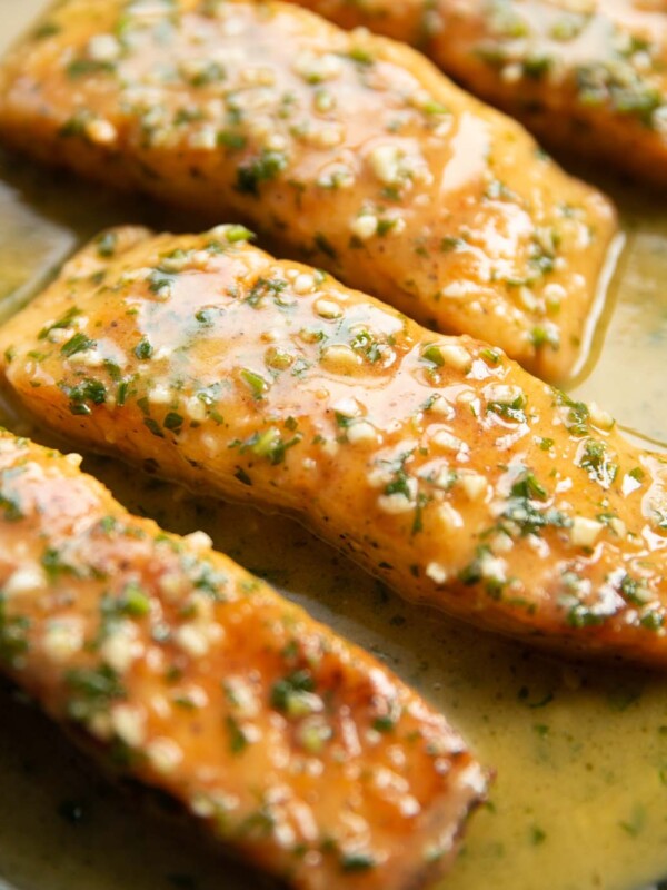 close up shot of garlic butter salmon fillets in pan