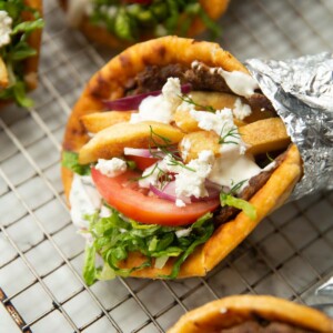 close up shot of ground beef gyros on wire rack wrapped in foil