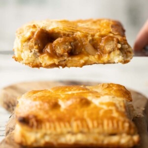 close up shot of knife lifting half a bangers and mash bake showing filling