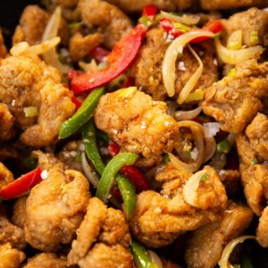 close up shot of salt and chilli chicken in black wok