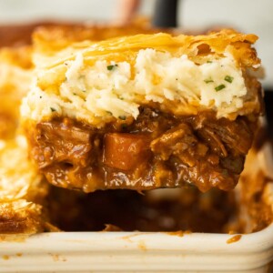 close up shot of spatula lifting portion of steak and guinness pie from baking dish