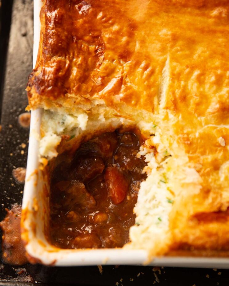 steak guinness potato pie in baking dish with scoop taken out showing filling