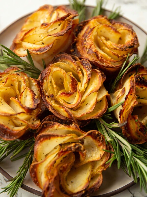 potato roses on small white plate with rosemary