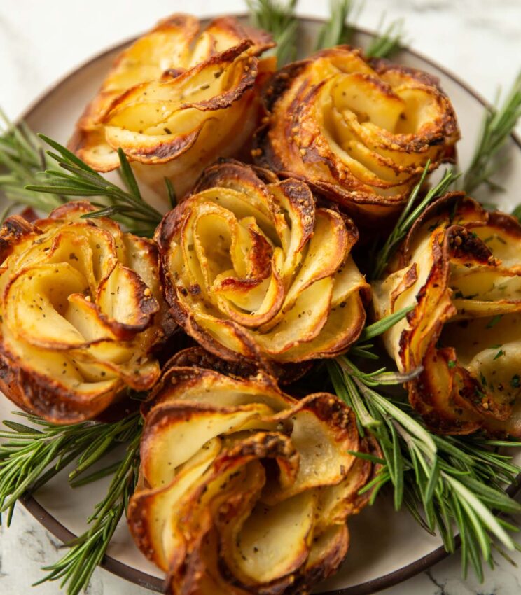 potato roses on small white plate with rosemary