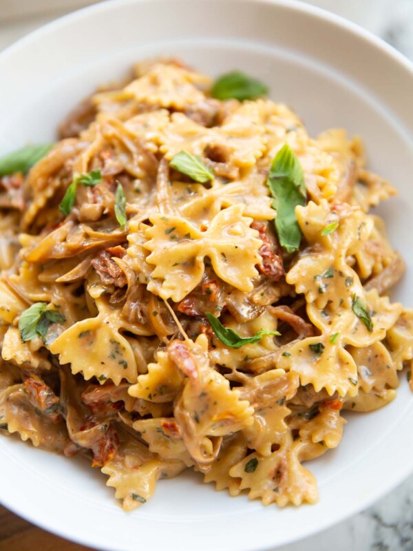 close up shot of caramelised onion pasta in large white bowl