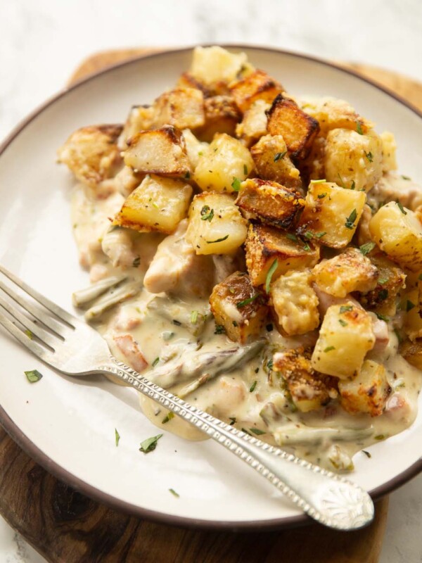 potato chicken tarragon bake on small white plate with silver fork