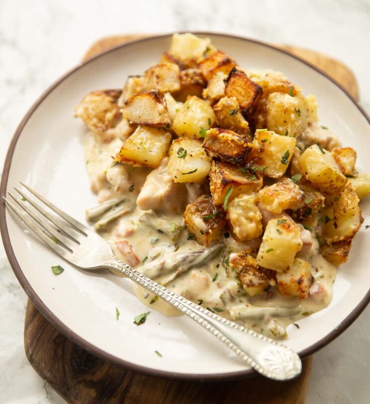 potato chicken tarragon bake on small white plate with silver fork