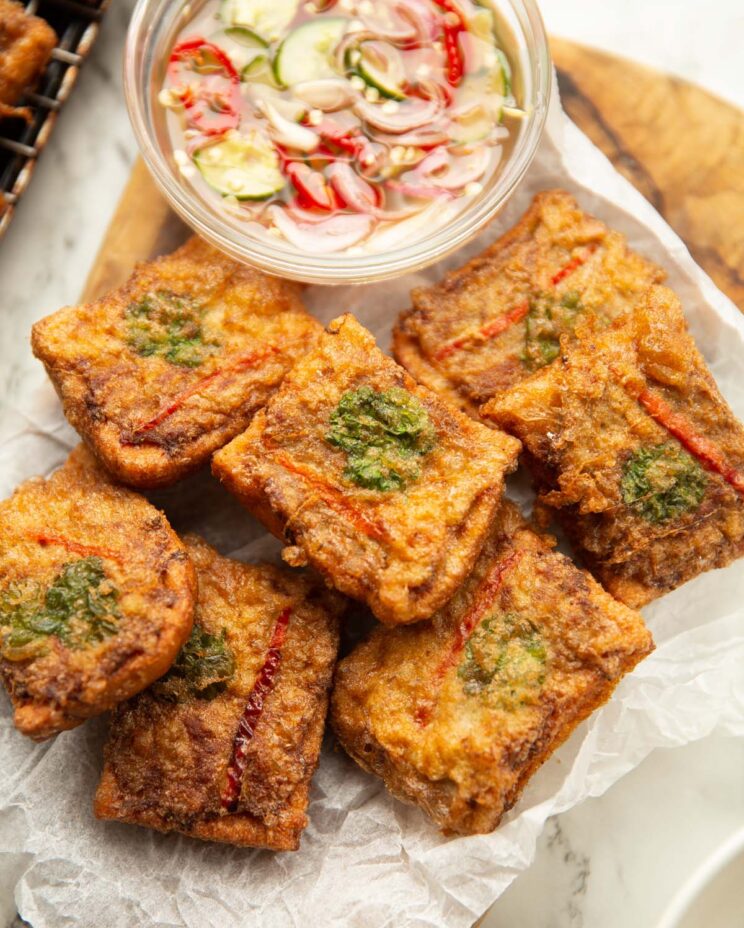 overhead shot of thai pork toast on wooden board with dipping sauce