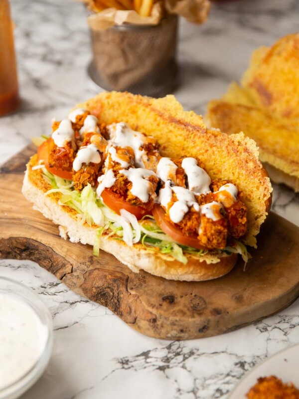 chicken tenders sandwich on wooden board showing filling